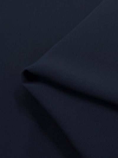 A close-up of Microfibre Suiting - Dark Navy from Super Cheap Fabrics shows its smooth, medium-weight texture, with gentle shadows and highlights on the slightly folded 150cm material.