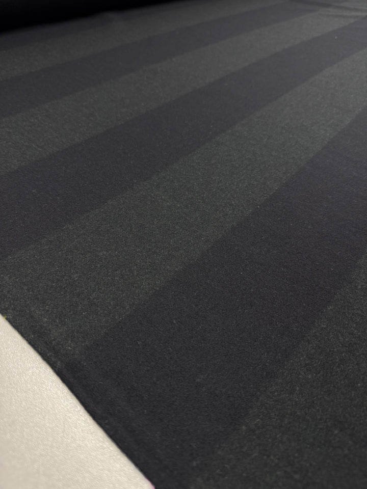 Close-up of the Virgin Wool - Two Tone Black Khaki fabric by Super Cheap Fabrics, showcasing subtle diagonal stripes in black and khaki. This elegant heavy-weight, 150cm wide textile offers a smooth and sophisticated pattern.