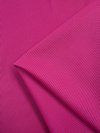 Close-up of the Super Cheap Fabrics Rib Knit in Hot Pink (130cm), showcasing its vibrant color, textured surface, and generous stretch in an overlapping pattern.