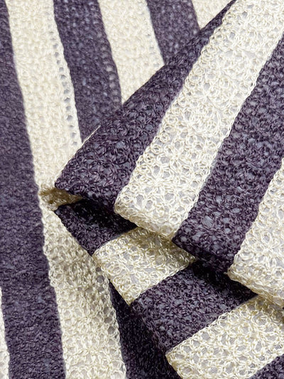 A close-up of the Pure Silk - Tuxedo Twist from Super Cheap Fabrics shows luxury with its alternating dark and light horizontal stripes. Its woven, slightly rough texture highlights the rich contrast, embodying high-end fashion's allure.