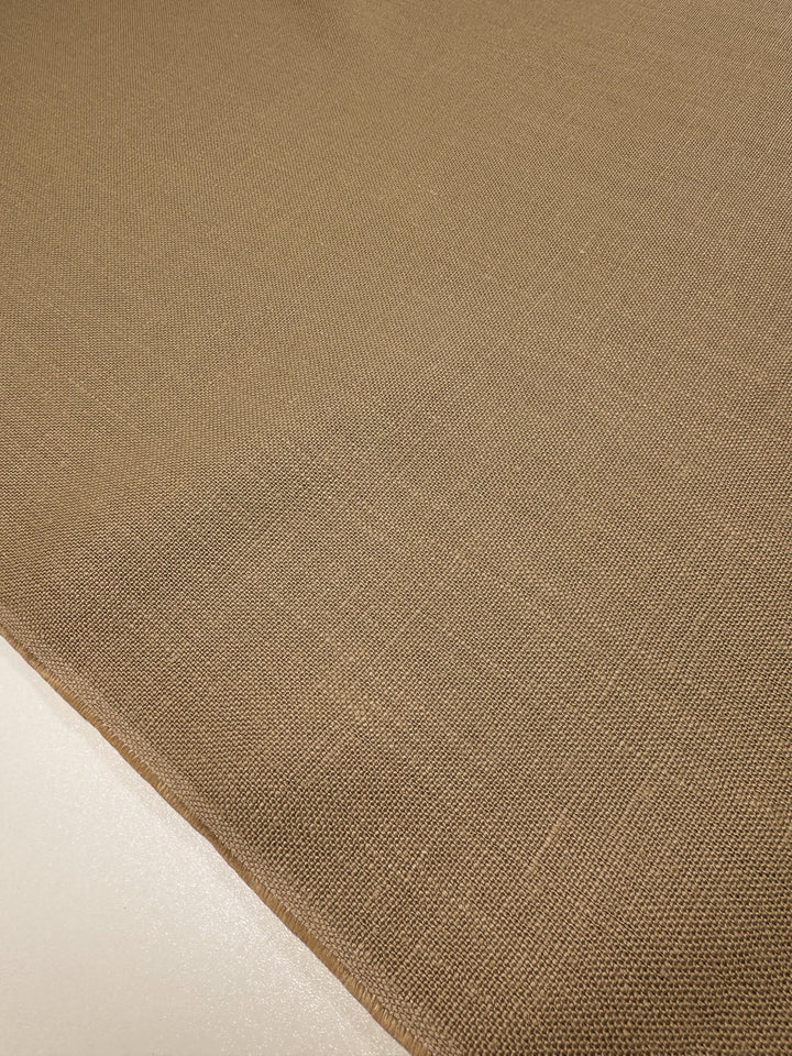 Close-up of Super Cheap Fabrics' Pure Linen in Iced Coffee, 143cm wide, highlighting its breathable weave and detailed edge stitching on a light surface.