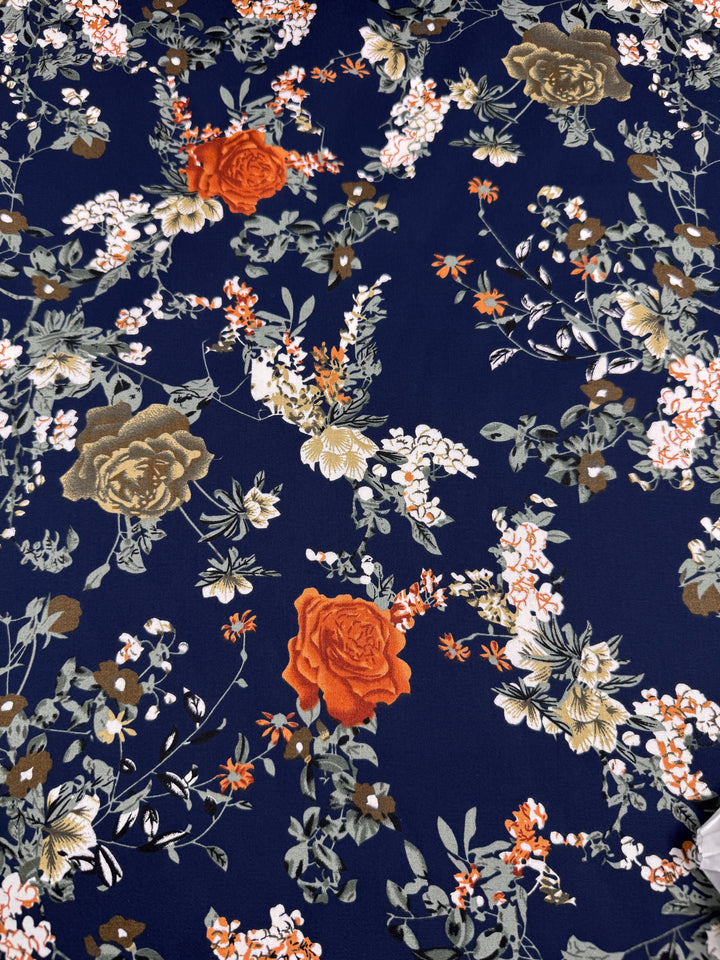 Super Cheap Fabrics' Cotton Sateen - Autumn Romance (145cm) features a lightweight navy fabric with large red and gold roses, white and orange blossoms, and green leaves—perfect for stylish cotton dresses.