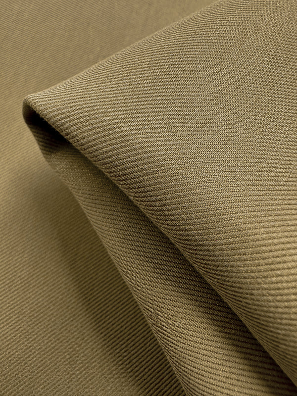 Close-up of neatly folded Designer Suiting - Incense - 140cm by Super Cheap Fabrics, showcasing visible diagonal weaves for a textured look. Arranged in sharp angles and soft shadows, this olive-green fabric is perfect for crafting elegant skirts, jackets, or coats with its smooth surface and subtle sheen.