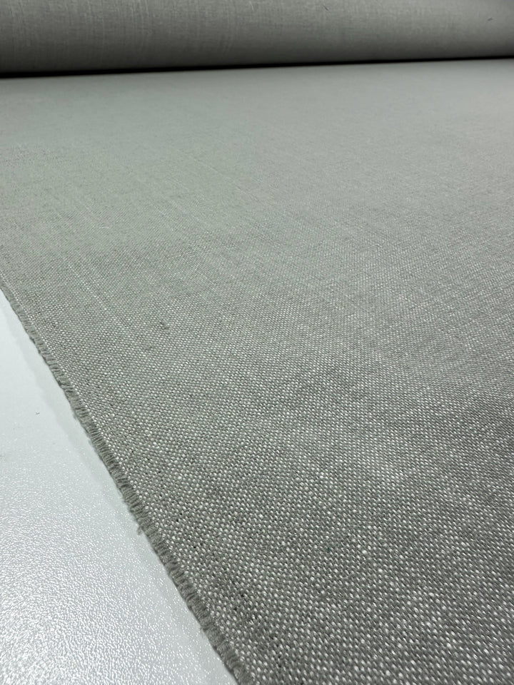 A close-up of Super Cheap Fabrics' Upholstery - Warm Silver - 142cm roll reveals detailed texture and perfectly aligned threads, showcasing its quality craftsmanship.