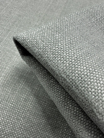 A detailed close-up of Super Cheap Fabrics' Upholstery in Warm Silver (142cm) showcases its soft appearance and intricate woven pattern.