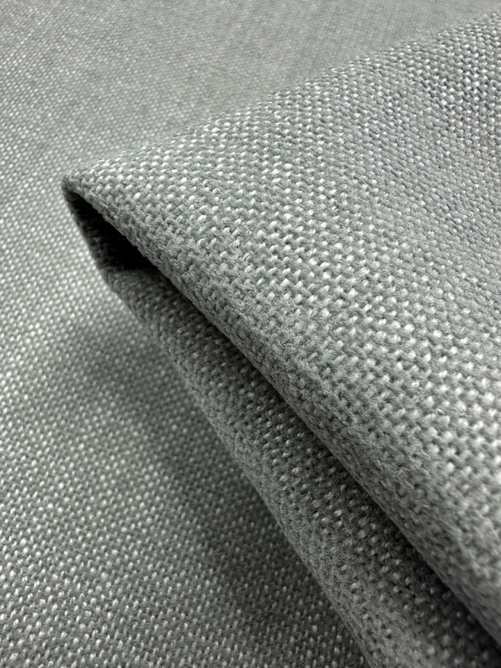 A detailed close-up of Super Cheap Fabrics' Upholstery in Warm Silver (142cm) showcases its soft appearance and intricate woven pattern.