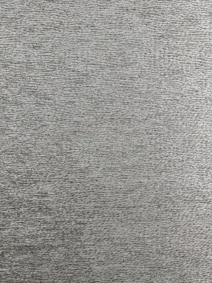The Upholstery Chenille Ezard in Silver Taupe by Super Cheap Fabrics features a textured gray surface with a subtle woven pattern, resembling chenille. It offers uniform color and an extra heavy weight texture for depth and a velvety hand-feel. Width: 145cm.