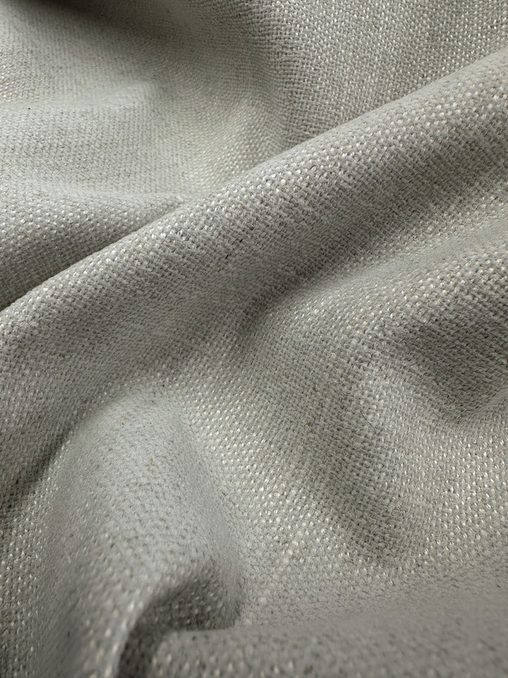 Close-up of Super Cheap Fabrics' Upholstery Basket Weave in Dresden Silver (145cm). This medium weight upholstery fabric features a structured texture and subtle sheen, with its basket weave pattern adding elegance while loosely draped for smooth folds and soft shadows.