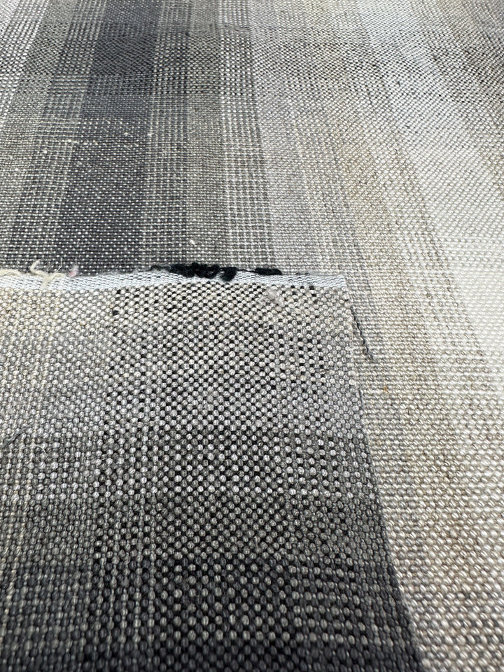 The Pure Linen - Natural fabric by Super Cheap Fabrics showcases a heavy-weight, textured weave with a patchwork design in gray and black. Its grid-like pattern offers subtle color and texture variations for a rustic, luxurious look.