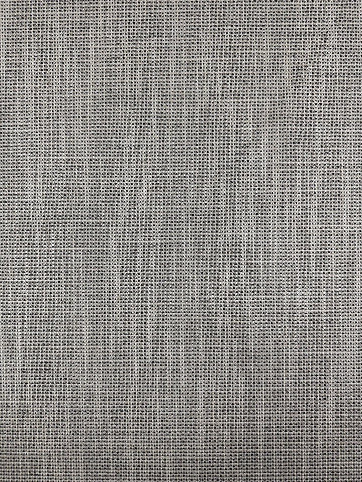 Close-up of Upholstery Logan - Salt & Pepper by Super Cheap Fabrics: a 145cm textured gray fabric with a woven grid pattern showcasing visible threads. Its subtle sheen gives a smooth, uniform look, ideal for accent pieces or clothing.