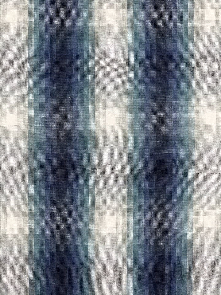 Crafted from heavyweight linen, Super Cheap Fabrics' "Pure Linen - Peacock - 148cm" features a plaid pattern with blue, gray, and white vertical stripes. The design's varying gradients offer a layered texture perfect for upholstery.