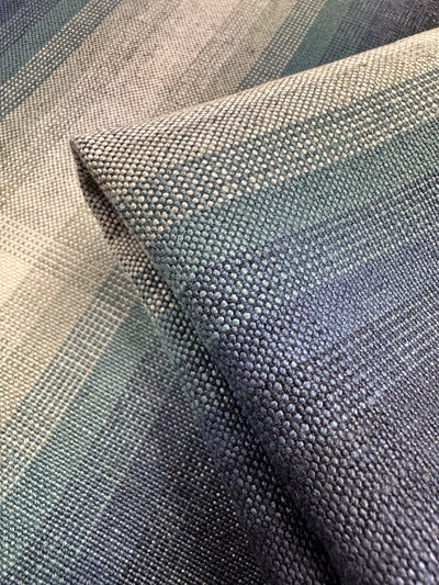 Close-up of Super Cheap Fabrics' Pure Linen - Peacock, a heavy weight linen with a textured grid pattern. The upholstery fabric features a gradient of green, blue, and beige shades for a soft, blended look. Width: 148cm.