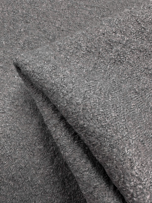 Close-up of two folded grey towels with a soft, textured surface resembling the plushness and luxurious feel of Boiled Wool Gull fabric by Super Cheap Fabrics, showcasing their inviting fluffy loops.