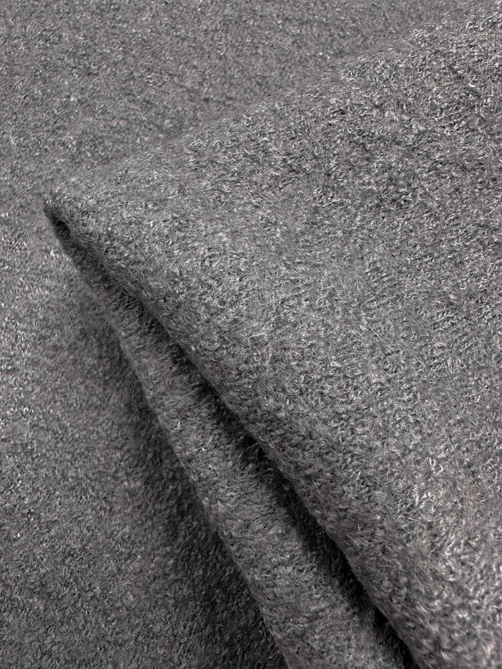 Close-up of two folded grey towels with a soft, textured surface resembling the plushness and luxurious feel of Boiled Wool Gull fabric by Super Cheap Fabrics, showcasing their inviting fluffy loops.