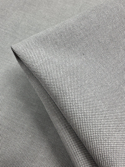 Close-up of folded Linen Blend - Grey White - 150cm by Super Cheap Fabrics, showcasing its fine textured weave and smooth surface, ideal for lightweight upholstery.