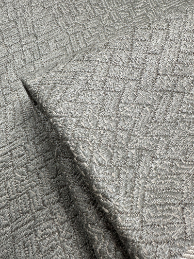 Close-up of Super Cheap Fabrics' Herringbone Textured Upholstery in Urbane Silver, 143cm wide, featuring a sophisticated raised crosshatch design with a shimmering metallic finish.