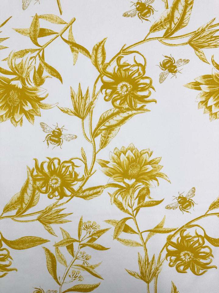 The "Cotton Duck - Bee Mustard - 150cm" by Super Cheap Fabrics showcases a nature-inspired design with intricate flowers and bees in spicy mustard tones on a white background, perfect for home décor.