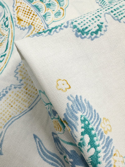 Close-up of folded Cotton Duck - Fine Lines by Super Cheap Fabrics, featuring a floral and abstract motif in teal, mustard yellow, and light blue on white. The medium weight texture highlights intricate design details perfect for a vibrant and artistic home décor look. Width: 147cm.