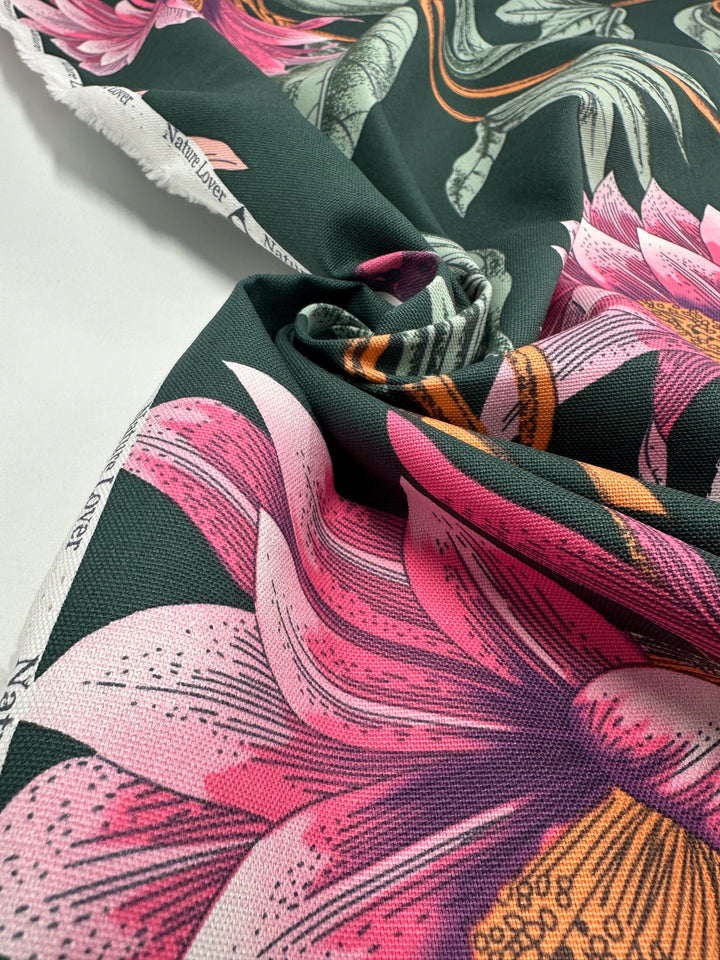 Close-up of "Cotton Duck - Tropical Punch - 147cm" by Super Cheap Fabrics, a medium-weight cotton fabric featuring pink, orange, and white floral patterns. Its vibrant design is perfect for lively home décor, with slightly wrinkled drapes adding texture to its colorful appearance.