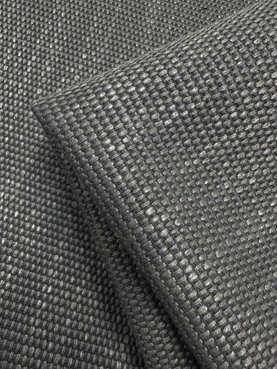 The Yari 117 - 147cm from Super Cheap Fabrics is a dark gray, heavyweight upholstery fabric with a textured, grid-like pattern reminiscent of lava smoke. It has a thick, sturdy appearance and a subtle sheen that highlights its high durability and quality.