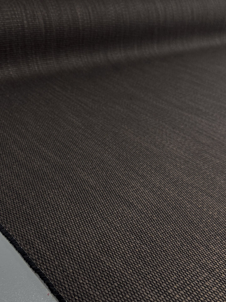 The Grid Upholstery - Yari 016 fabric by Super Cheap Fabrics features a textured black weave pattern. Its high durability and structure are highlighted under lighting, making it ideal for heavy-use furniture at 147cm width.