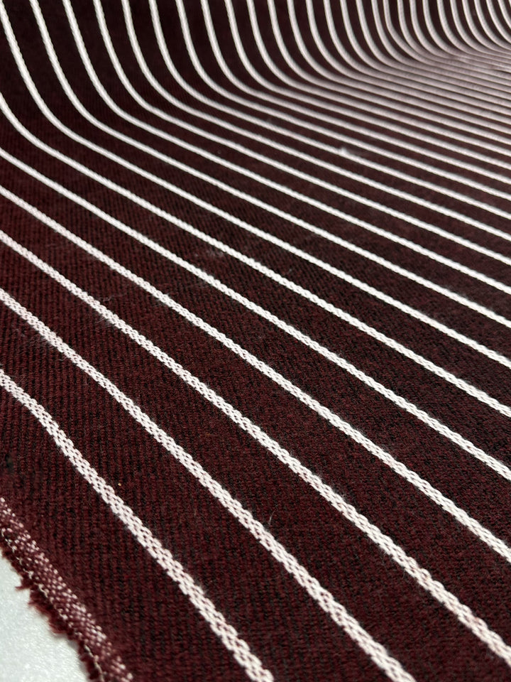 Close-up of Designer Tweed - Plum Line by Super Cheap Fabrics, showcasing maroon polyester fabric with white vertical stripes. The texture suggests a soft, deep feel typical of heavy-weight fabrics perfect for outer coats; the image captures the pattern and material flow impeccably.