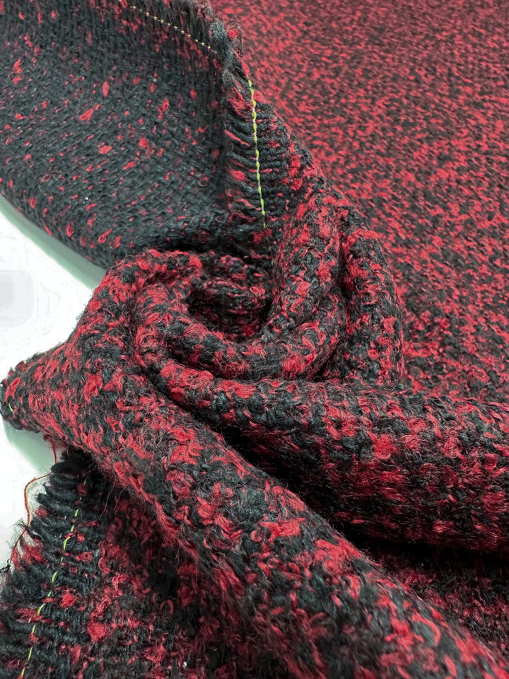 Close-up of Designer Tweed - Red Fluff - 150cm by Super Cheap Fabrics. This heavy-weight fabric features a red and black speckled pattern and cozy woven texture, shown with folds, perfect for outer coats.