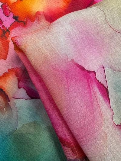 Indulge in the luxury of Super Cheap Fabrics' Designer Cotton - Monique. This 150cm piece boasts watercolor-like patterns in pink, red, orange, and green. It's soft and elegantly folded, ideal for creative designs requiring vibrant blending and seamless color transitions.