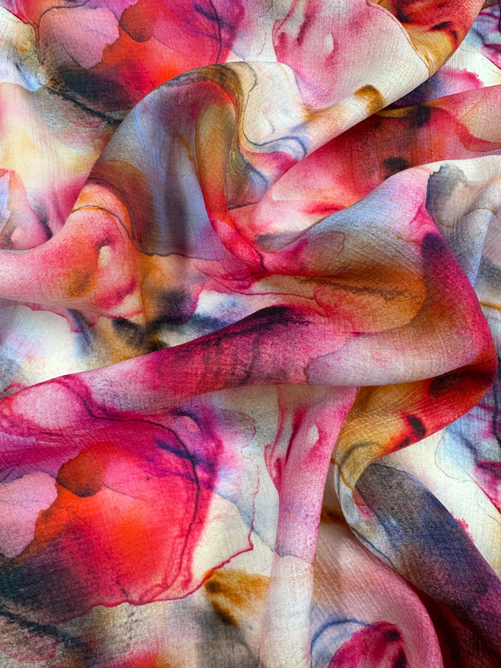 Super Cheap Fabrics' Designer Cotton - Zabaleta, 150cm features abstract watercolor patterns in vibrant red, pink, orange, and black. Its swirling designs and delicate texture make it ideal for luxury sewing projects requiring breathable fabric to enhance movement and vibrancy.