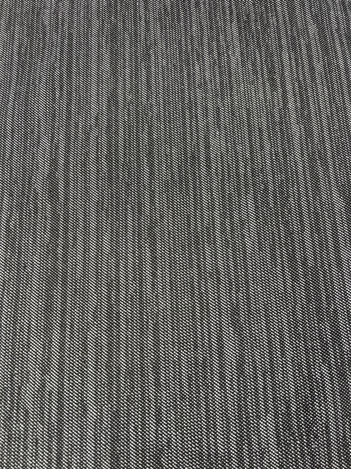 Close-up image of a textured fabric with a uniform pattern, ideal for furniture upholstery. The black and white weave creates a subtle checkerboard appearance. The texture is slightly coarse, suggesting the durable fabric might be Upholstery Twill - Salt & Pepper - 147cm from Super Cheap Fabrics.