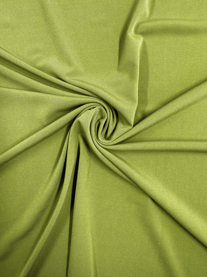 Super Cheap Fabrics’ ITY Knit - Golden Cypress - 150cm is an olive green polyester spandex with a smooth finish, softly gathered into a central spiral—perfect as a medium weight fabric for many versatile projects.