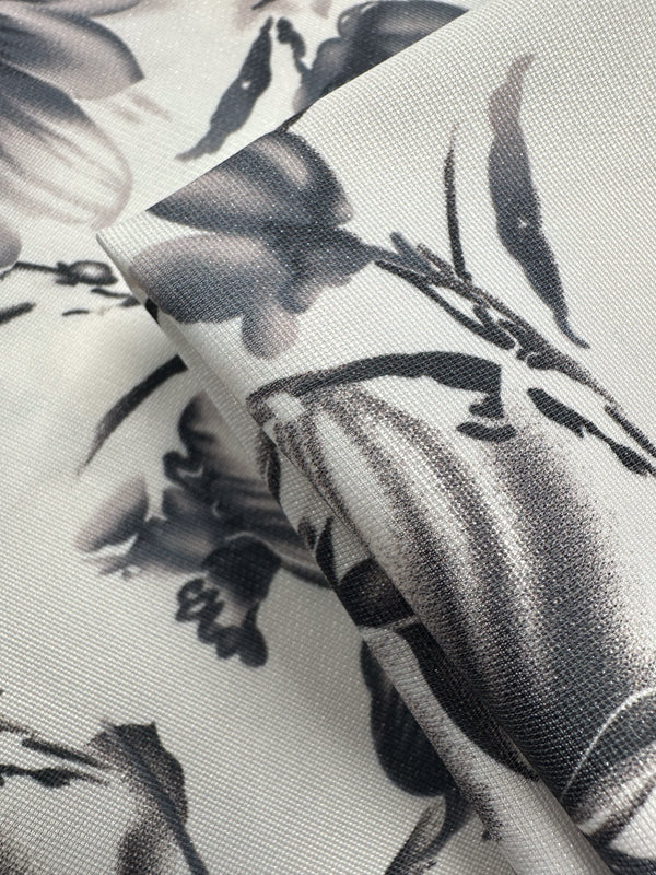 Close-up of folded Designer Deadstock - Inkveil - 145cm from Super Cheap Fabrics featuring a black and gray floral pattern on light viscose, showing textured details. Ideal for unique ex-designer projects.