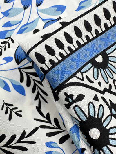 Close-up of Designer Rayon - Mosaic Valley by Super Cheap Fabrics: Mediterranean-inspired floral and leaf pattern in black and blue shades on white, with bold outlines and decorative borders; 145cm wide.