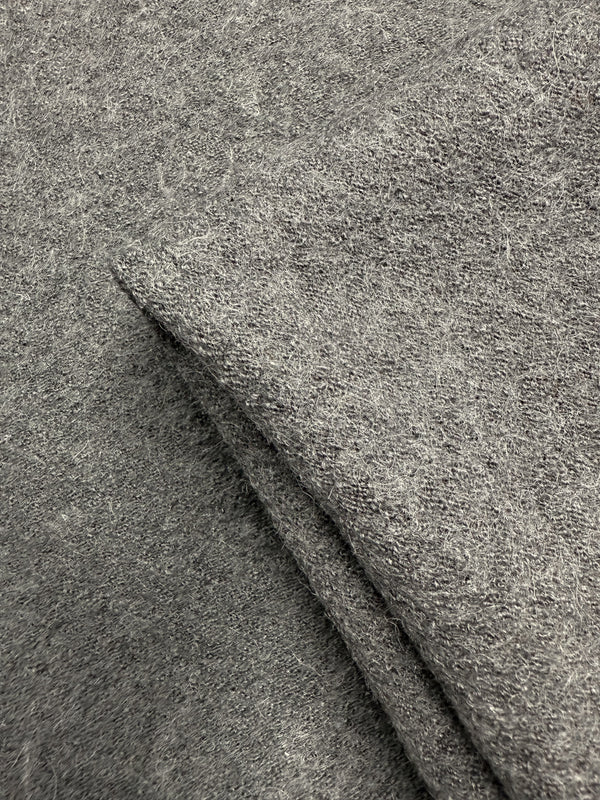Close-up of Boiled Wool - Ghost Gray (145cm) from Super Cheap Fabrics shows its soft, fuzzy texture and visible fibers. The folded wool-viscose blend creates cozy layers, making it perfect for winter garments.