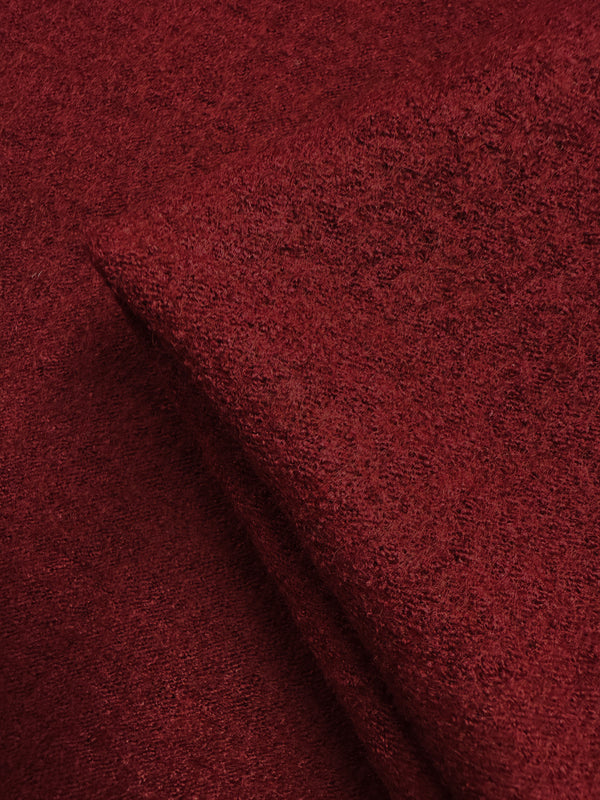 Close-up of Boiled Wool - Rhubarb - 145cm from Super Cheap Fabrics, highlighting its rich texture, deep red hue, and soft, slightly fuzzy surface. The neatly folded fabric showcases its thickness and tactile quality.