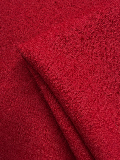 Close-up of Super Cheap Fabrics' Boiled Wool - Crimson (145cm), displaying its soft, textured, and slightly fuzzy red heavyweight wool surface.