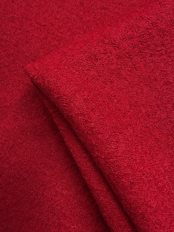 Close-up of Super Cheap Fabrics' Boiled Wool - Crimson (145cm), displaying its soft, textured, and slightly fuzzy red heavyweight wool surface.