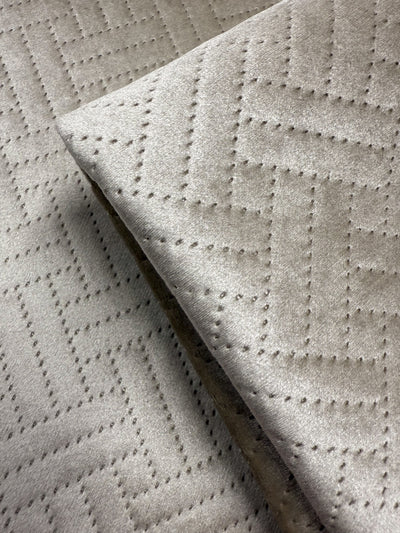 Close-up of Super Cheap Fabrics’ Embossed Velvet - Oatmeal (150cm), an extra heavyweight fabric with a soft texture and geometric zigzag pattern from small, even perforations—perfect for upholstering sofas or armchairs.