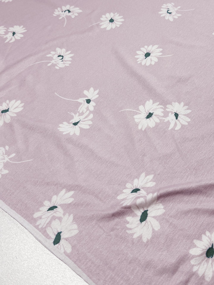 The "Daisy Pink" from Super Cheap Fabrics features a pale pink cotton Lycra fabric with white daisies, highlighted by dark centers for a charming aesthetic. Medium weight adds stretch and comfort to this enchanting 150cm design.