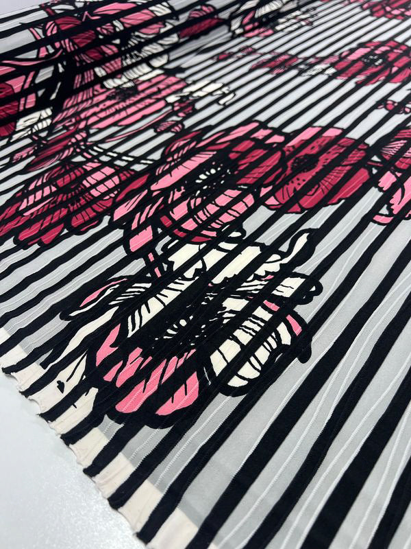 The Textured Lycra - Poppy Dream by Super Cheap Fabrics features medium-weight fabric adorned with large pink and red flowers over black and white stripes, enhanced by detailed black outlines for a bold, vibrant look. With a width of 150cm, it offers dynamic contrast against geometric patterns.