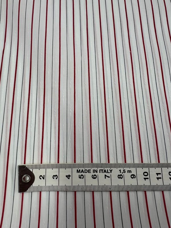 Shirting - Pins - 145cm by Super Cheap Fabrics is a lightweight polyester cotton fabric with thin red and silver vertical stripes on white, shown with a centimeter tape and labeled "MADE IN ITALY.