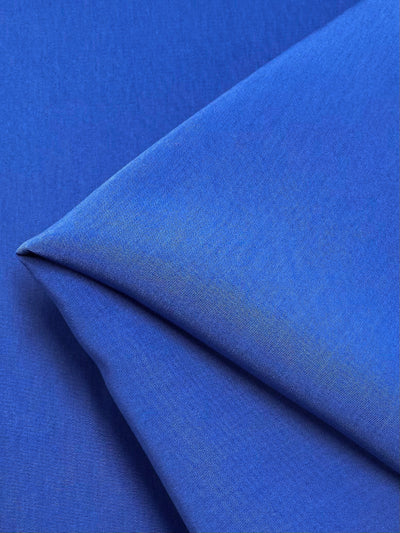 Super Cheap Fabrics' "Microfibre Suiting - Bright Cobalt - 150cm" is a soft, medium-weight polyester fabric with a smooth texture and gentle weave pattern. Its rich cobalt hue displays subtle shadows and highlights, enhancing its vibrant appearance.