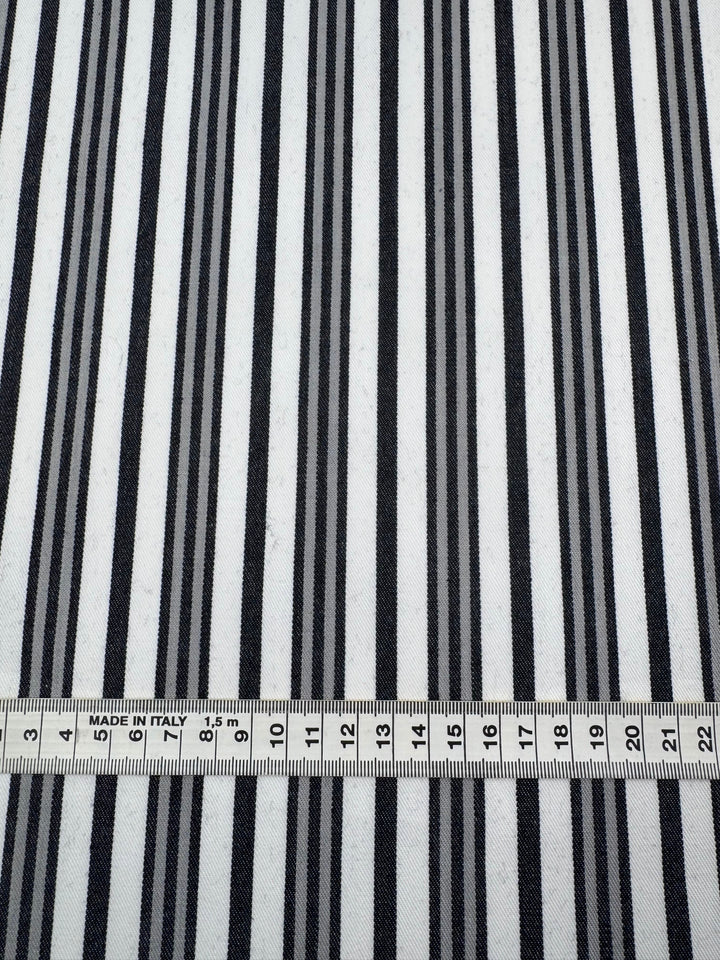 The Super Cheap Fabrics Cotton Drill - Allsorts fabric features durable black and white vertical stripes with a ruler at the bottom showing 0-23 cm measurements, highlighting its precise stripe width and spacing in a sturdy diagonal weave. Width: 147cm.