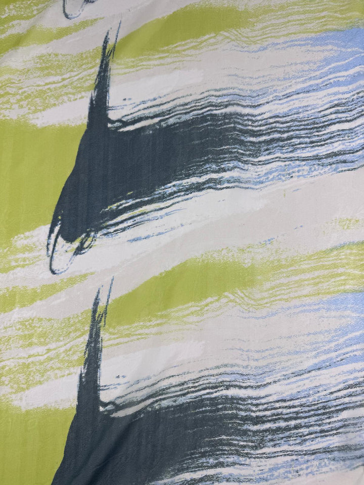 The "Pure Silk - Speed - 112cm" by Super Cheap Fabrics captures the essence of luxury fabric with bold brush strokes in dark blue, lime green, and white. Its horizontal layers blend colors dynamically, evoking movement and an energetic fashion-inspired feel.